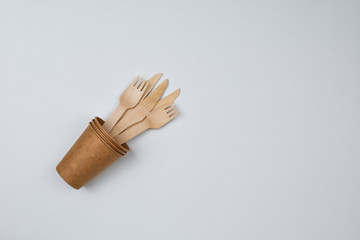 Zero waste concept. Forks and knives in a paper cup on a white background.