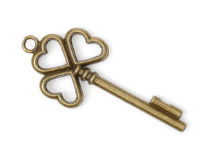 old brass key against a white background