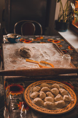 Cooking dumplings at home, dough and flour with dumplings on a wooden board.2020