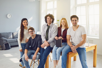 Portrait of a happy group of university college students in a room.