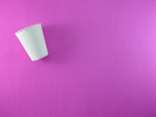 Recycled paper container on a bright pink background.