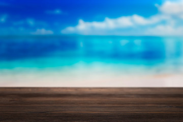Empty wooden terrace on the beach with blurred water and sky. Close-up view with selective focus.