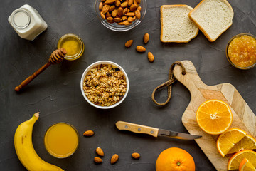 Fototapeta premium Granola for healthy breakfast. Still life composition with fruits and toast on grey background top-down