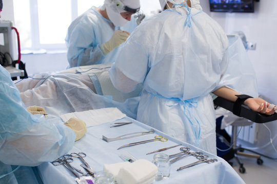 Medical team of surgeons in hospital doing minimal invasive surgical interventions. Surgery operating room with electrocautery equipment for cardiovascular emergency surgery center..