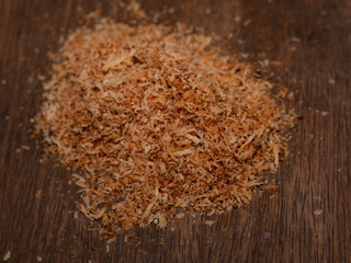 Close-up grated coconut with a wooden board background.