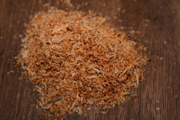 Close-up grated coconut with a wooden board background.