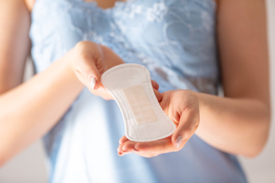 Young Woman Holding Menstrual Pad. Sanitary Napkin And Female Hygiene Concept