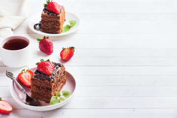 Truffle cake with chocolate and strawberries and mint on a white wooden table. Selective focus. Copy space