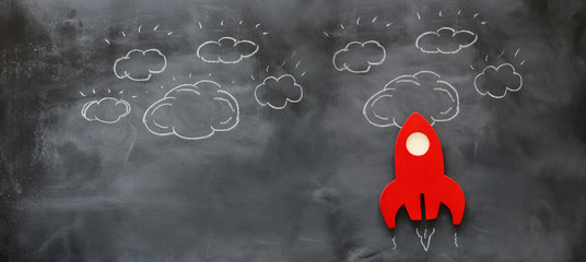 education or innovation concept. Wooden rocket over blackboard background. top view