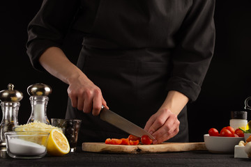 Chef slices cherry tomatoes to make shrimp marinade sauce. Seafood and oriental recipes.
