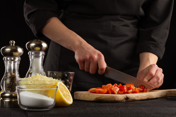 Chef slices cherry tomatoes to make shrimp marinade sauce. Seafood and oriental recipes.