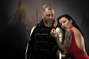 Beautiful girl in a red dress and knight in armor