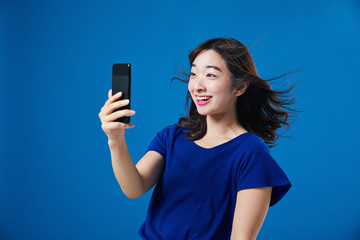 スマートフォンを持って驚く女性