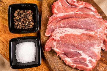 close up. a pork on wooden with salt, pepper.