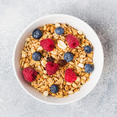 Healthy breakfast. Fresh granola, muesli with yogurt and berries on grey background. Copy space