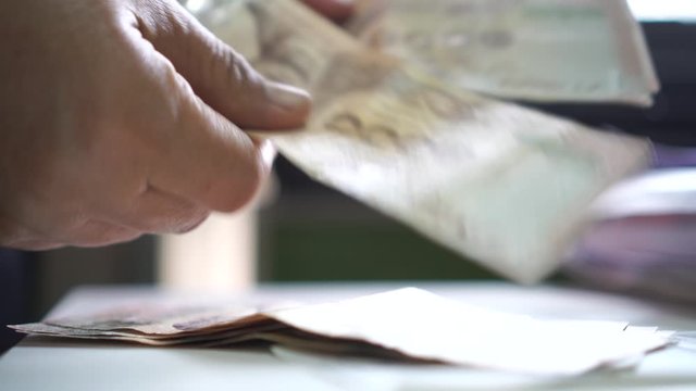 Weak baht, Thai baht banknotes, Businessman's hands counting money. one thousand baht. (THB) is official currency of Thailand. Finance and banking business in Asia, impact of global economy from virus