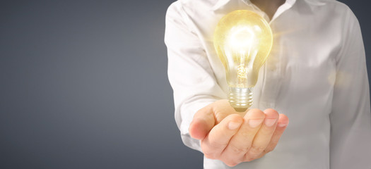 Hand of holding illuminated light bulb. innovation inspiration concept