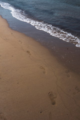 Footsteps on Greek sandy beach