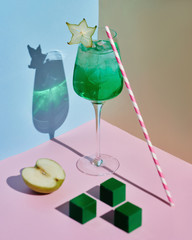 Evening cocktail with apple stands on color backgrounds