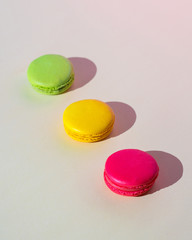 Beautiful macaroons lie on a colored background on a sunny day