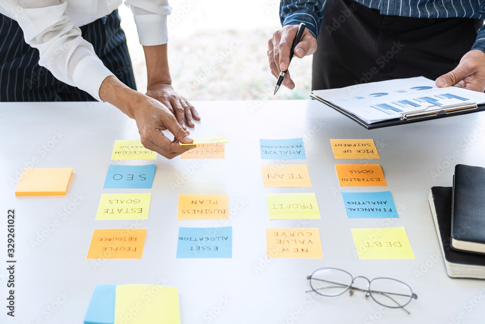 Poster Two creative business people meeting and planning use post it notes sticky note on desk to share idea, Analysis data chart and graph with teamwork strategy brainstorming in office