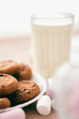 Chocolate cakes on the light table with milk and marshmallows.