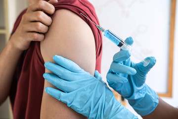 Doctor making injection vaccination patient to prevent pandemic of the disease, flu or influenza...