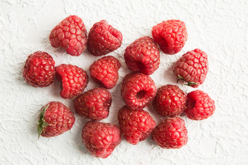 Stack of fresh red raspberries over white textured background
