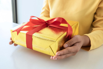 Young woman holding gift box each other with birthday greeting or celebration day and christmas