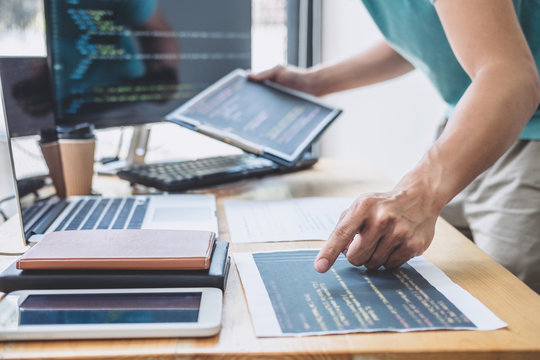 Young Professional programmer working at developing programming and website working in a software develop company office, writing codes and typing data code, Programming with HTML, PHP and javascript