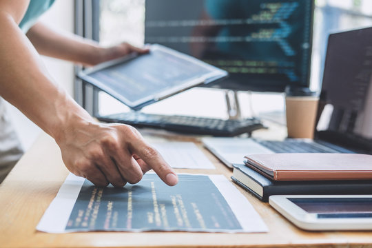 Young Professional programmer working at developing programming and website working in a software develop company office, writing codes and typing data code, Programming with HTML, PHP and javascript
