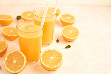 freshly squeezed orange juice in glasses on the kitchen table with slices of oranges, concept of diet and healthy lifestyle