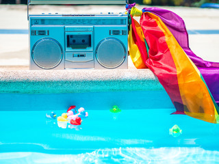 A cassette with an lgtb flag with rubber ducklings in the pool