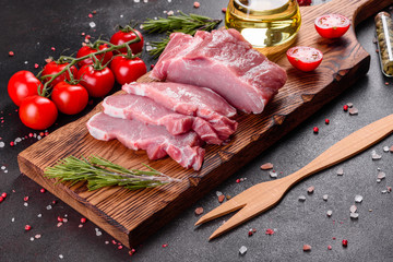 Fresh pieces pork ready to cook on a dark background in the kitchen
