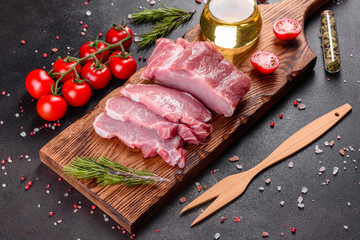 Fresh pieces pork ready to cook on a dark background in the kitchen
