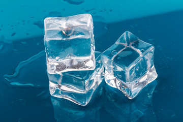 ice cubes and water drops close up on blue background
