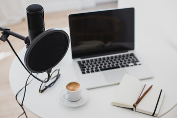 Microphone, earphones and laptop on table. Podcast