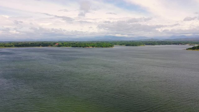 Beautiful lake and mountains in the distance. View of the Paoay Lake, Philippines. Big lake on a tropical island. Summer and travel vacation concept.