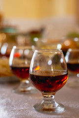 Close up of lot of glasses of fresh cognac on bar table. Party and holiday celebration concept