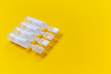 physiological serum ampoules on a yellow background