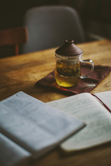 Books and glass cup of green tea on the wooden table