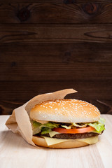 Burger general view from the side on a wooden background. Close up.