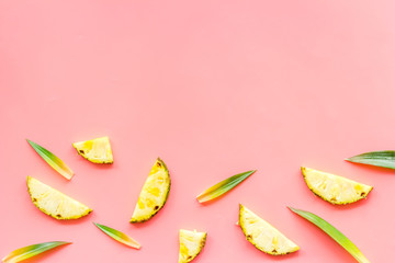 Pineapple slices on pink background top-down frame copy space