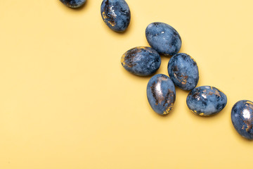 Flat Lay of Golden Easter Eggs in row placed on yellow background. Easter background or easter concept.