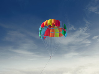 Fototapeta na wymiar The colorful parachute stripes on the sky,Summer Camp in Beach