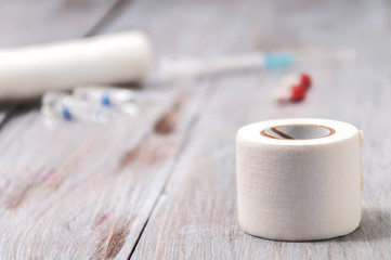Bandage, pills, syringe on a gray wooden background. Health care. Ambulance. First Aid Kit. Healthcare and medicine.