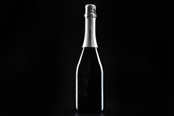 Champagne bottle on dark black background close up