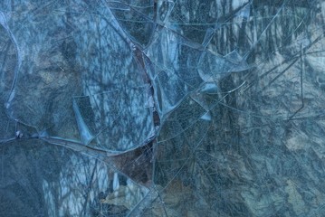 gray dark texture of a broken piece of glass with cracks