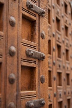 Large ornate wooden doors with metal latch and studs