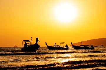 Traditional long-tail boat on the beach at sunset in Thailand